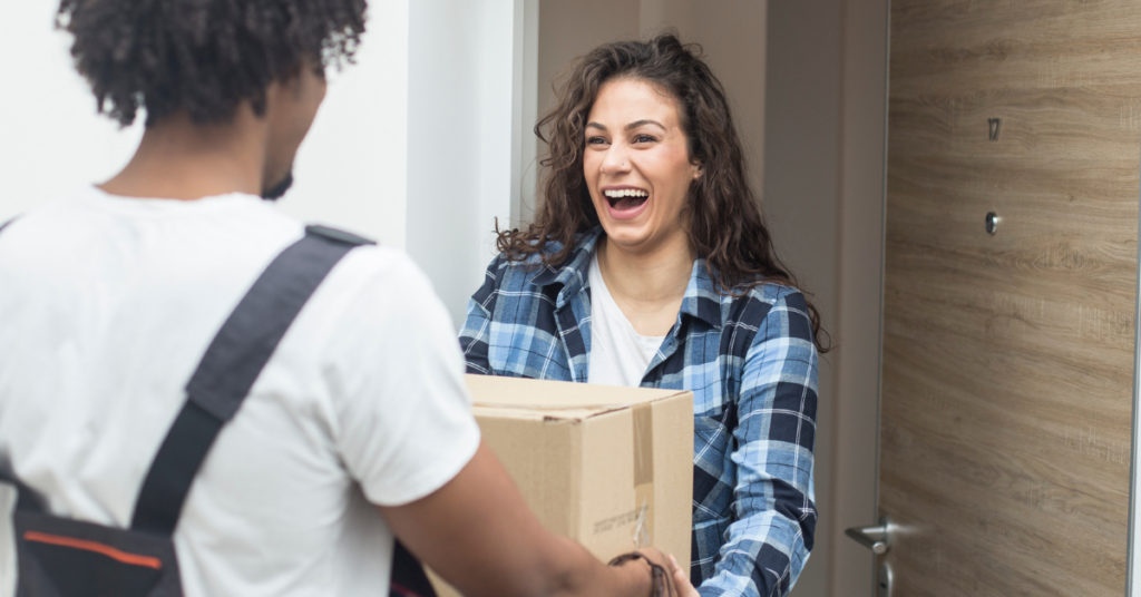 excited woman receiving package from delivery man