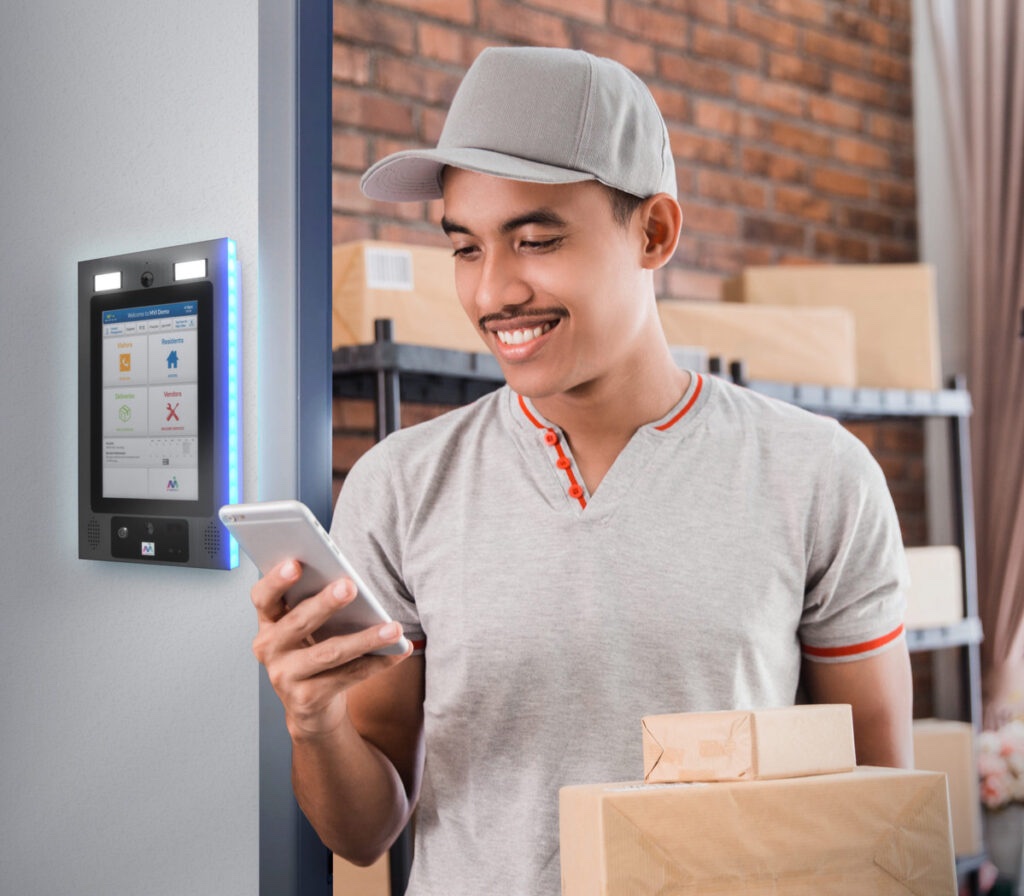 delivery man on phone holding packages by keycom system