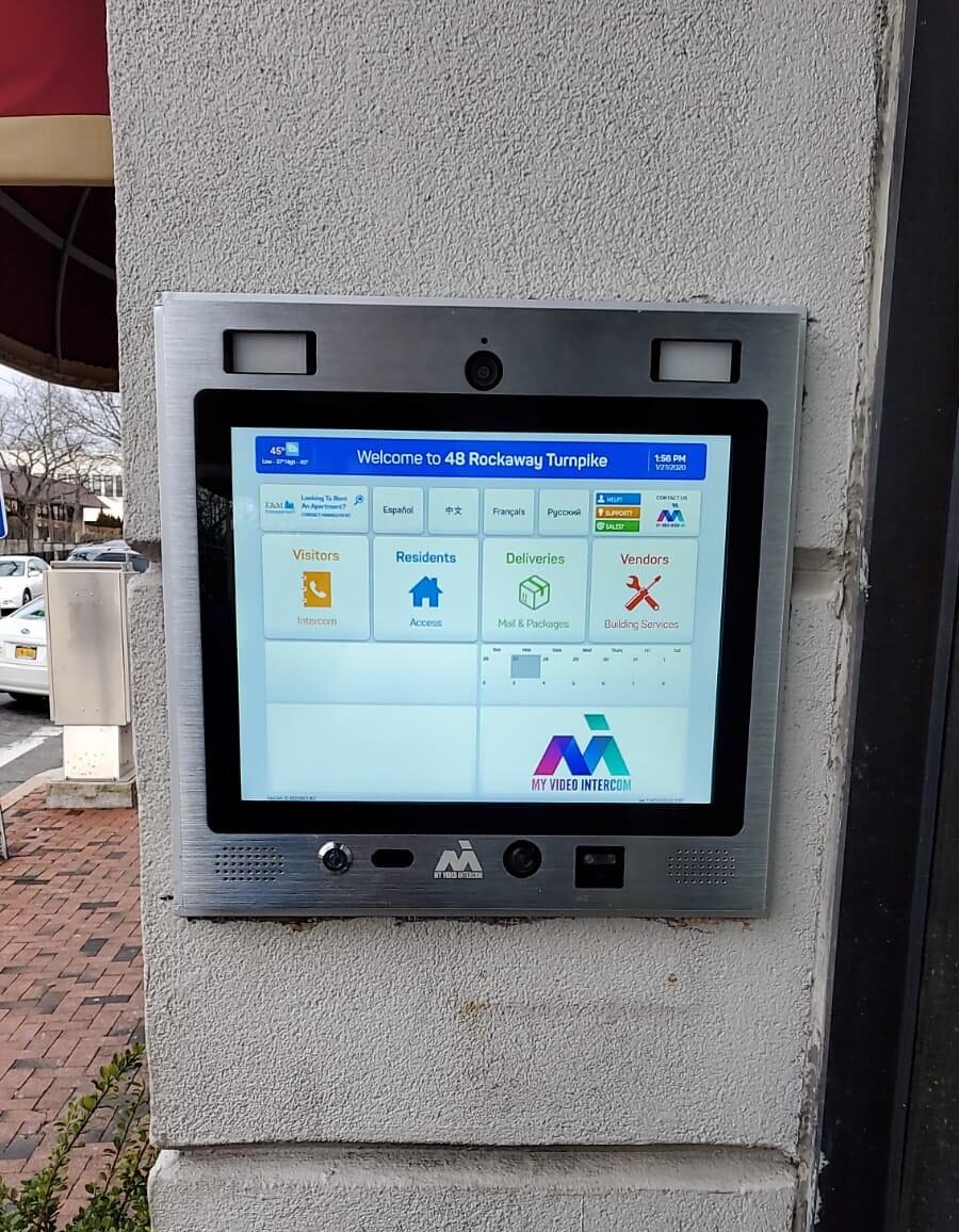 mvi keycom mounted on white stone wall by apartment building entrance