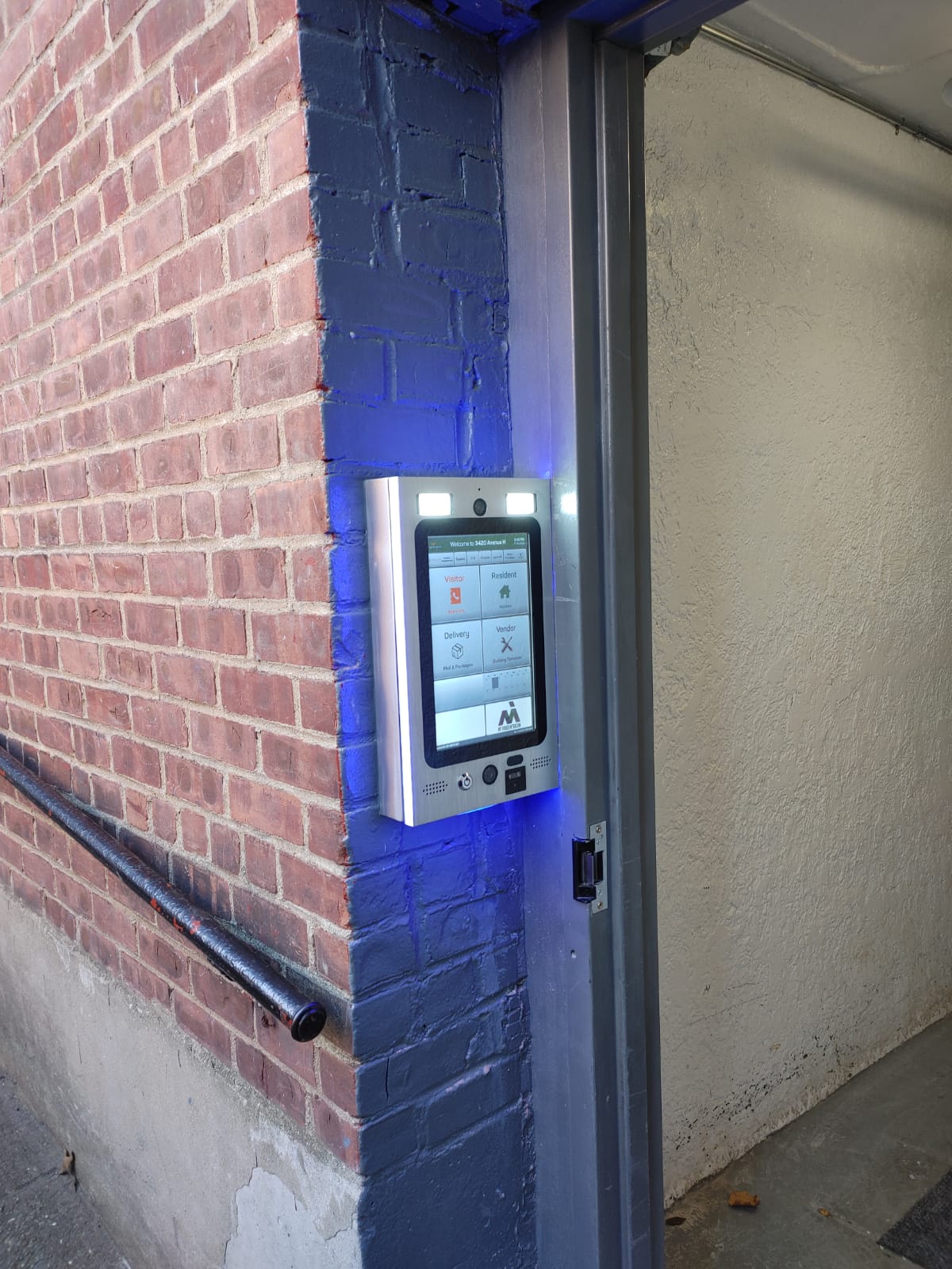 mvi keycom mounted on brick wall by building entrance