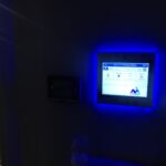 mvi keycom mounted on wall being illuminated by blue light