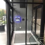 mvi keycom system mounted on grey wall by building entrance