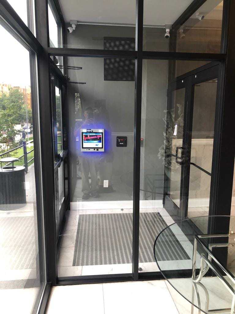 mvi keycom system mounted on grey wall by building entrance